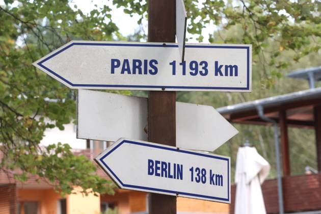 View on Wednesday 04 10 2023 in Neubrandenburg Landkreis Mecklenburgische Seenplatte at the local Tollensesee on a signpost with the directions Paris and Berlin The Four Gates City is currently cooperating with numerous places in Germany and Europe