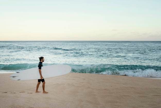 Creative Highlights Symbolbilder Mann hält sein Surfbrett im Meer *** Man holds its Surfboard at Sea Copyright: imageBROKER/OleksandrxLatkun iblole09805307.jpg ,model released, Symbolfoto ,property released