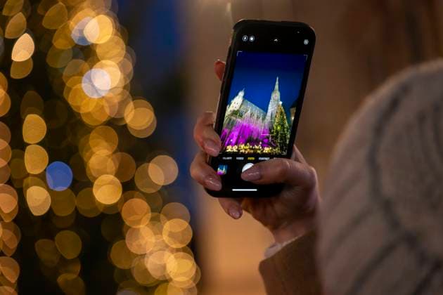 20.11.2023, Hauptstadt Wien (Österreich) erstrahlt im vorweihnachtlichem Glanz, Impressionen vom Weihnachtsmarkt am bunt beleuchteten Stephansdom. Eine Touristin fotografiert mit ihrem Handy. 20.11.2023, Wien in der Vorweihnachtszeit 20.11.2023, Wien in der Vorweihnachtszeit *** 20 11 2023, Capital city Vienna Austria shines in pre-Christmas splendor, Impressions of the Christmas market at the colorfully illuminated St. Stephens Cathedral A tourist takes a photo with her cell phone 20 11 2023, Vienna in the run-up to Christmas 20 11 2023, Vienna in the run-up to Christmas