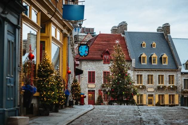 A charming old street adorned with vibrant Christmas decorations and illuminated trees, capturing the holiday spirit in a historic setting in Quebec, Canada Model Released CamilleGirard_ID13407_408514_029 Copyright: xCamillexGirardx