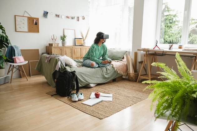 IMAGO Creative, Lifestyle, Gaming Teenage girl wearing virtual reality simulators playing video game with controller at home model released, Symbolfoto property released, ALKF00664