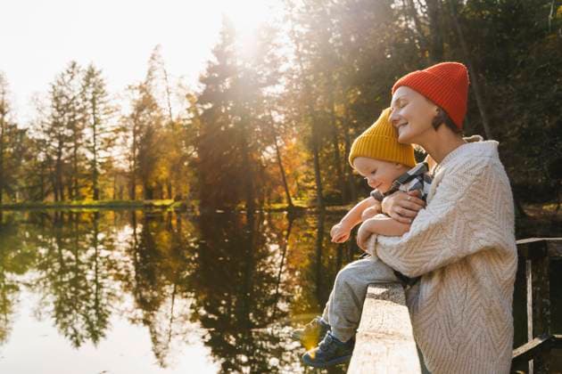 Happy mother hugging son sitting on railing near lake model released, Symbolfoto, NDEF01355