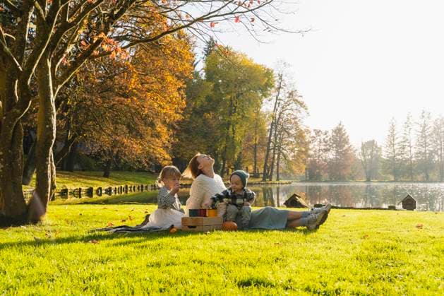 IMAGO Creative, Ostern, Bräuche, Osterspaziergang Smiling mother relaxing and spending time with children on picnic model released, Symbolfoto, NDEF01361