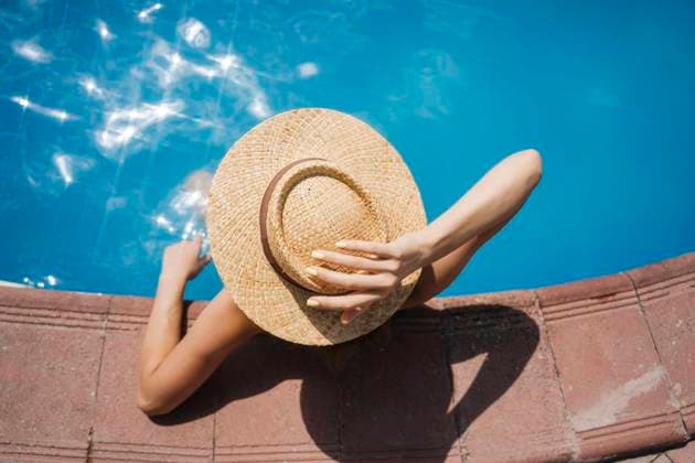Woman wearing straw hat relaxing in pool on sunny day model released, Symbolfoto, YBF00280