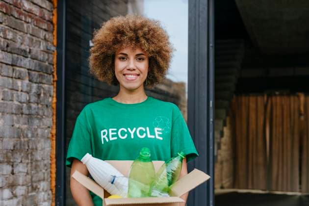 Creative Highlights Symbolbilder Smiling activist holding cardboard box with plastic bottles model released, Symbolfoto property released, YTF01296