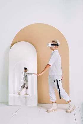 Creative Highlights Symbolbilder Woman wearing virtual reality headset touching reflection of man in mirror on wall model released, Symbolfoto property released, YTF01364