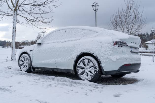 Bavaria, Germany - November 26, 2023: A snow-covered electric car of the Tesla brand, Tesla Model Y covered with snow