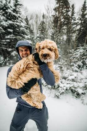 Creative Highlights Symbolbilder Young man holds his labradoodle dog in snow and cold on walk Conway, New Hampshire, United States CR_SSNF231128C-1095928-01 ,model released, Symbolfoto