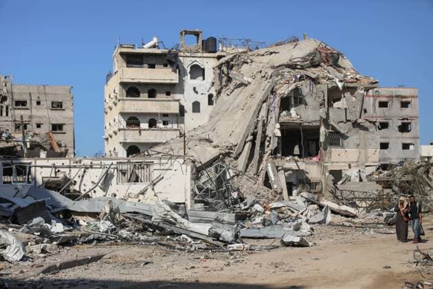 (231129) -- GAZA, Nov. 29, 2023 -- People walk past destroyed buildings in Gaza City, on Nov. 29, 2023. After weeks of Israeli strikes on Gaza in retaliation for an attack on Oct. 7 by Hamas against Israel, the two sides reached a four-day humanitarian truce last week, which was extended for another two days starting on Tuesday. The Palestinian death toll from the Israel-Hamas conflict has surpassed 15,000, according to Palestinian figures. Israel said that the Hamas attack killed about 1,200 people while more than 200 people were taken as hostages. (Photo by Xinhua) MIDEAST-GAZA CITY-ISRAEL-HAMAS CONFLICT-AFTERMATH MohammedxAli 