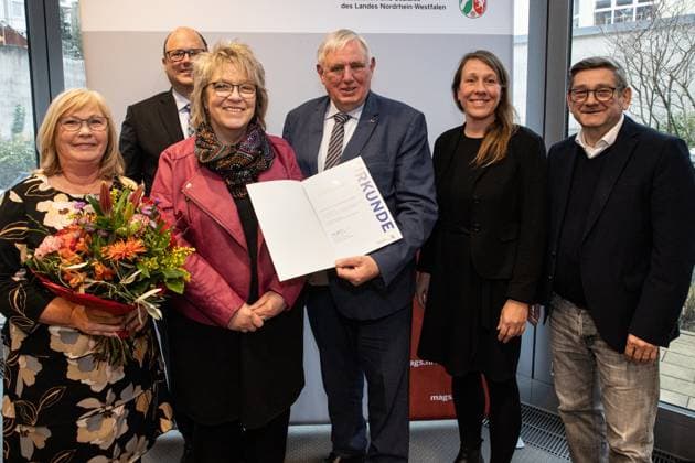 04.12.2023. Düsseldorf. NRW-Gesundheitsminister Karl-Josef Laumann überreicht den Gesundheitspreis Nordrhein-Westfalen. Mit dem ersten Platz zeichnete Minister Laumann das Dortmunder Projekt Randzeitenbetreuung aus. Die LWL-Klinik Dortmund und das Krankenhaus SJG St. Paulus bieten gemeinsam mit dem Kooperationspartner Dortmunder Mütterzentrum ein zuverlässiges Betreuungsangebot in Randzeiten für Eltern, die in der Pflege oder im ärztlichen Dienst der Kliniken tätig sind. Damit werden insbesondere Pflegekräfte dabei unterstützt, im Schichtdienst Beruf und Familie zu vereinbaren. Hier: Vertreter innen des ausgezeichneten Projektes, NRW-Gesundheitsminister Karl-Josef Laumann und Josef Neumann, MdL. Düsseldorf NRW-Ministerium für Arbeit, G