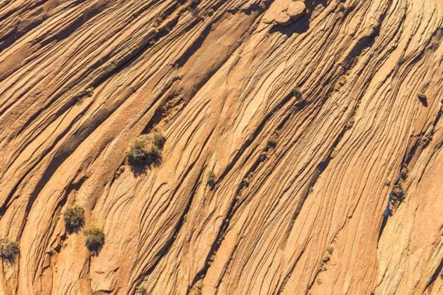 An aerial shot captures the intricate, wavy patterns of rock formations in a desert landscape, illustrating the beauty of natural erosion. Model Released JuanLopez_ID17454_529871_009 Copyright: xJuanxLopezx