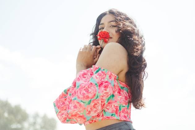 Creative Highlights Symbolbilder MR_ID13103_13016_AndreaCarminaGonzalezFlores.jpg From below side view of attractive young female holding red flower touching lips and looking at camera while standing under bright sunshine and blurred background Model Released AlbaCaro_ID13103_398941_025 Copyright: xAlbaxCarox RECORD DATE NOT STATED