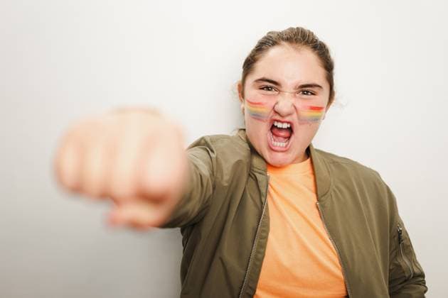 Creative Highlights Symbolbilder Serious young girl standing near gray wall with closed fist Excited fun loving teenage girl with opened mouth looking at camera while standing in karate pose with blurred closed fist against gray wall in light Model Released HodeiUnzueta_ID16136_491135_024 Copyright: xHodeixUnzuetax