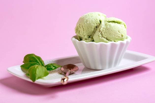Homemade ice cream (sundae) with basil. Basil ice cream in ceramic bowl on a pink background, served with fresh basil leaves. Copy space. Selective focus. Copyright: xZoonar.com MarinaxSaprunovax 20668226