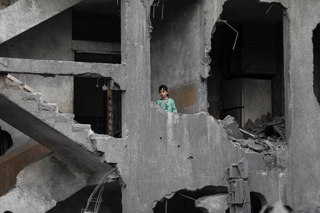 December 7, 2023: Gaza, Palestine. 07 December 2023. A Palestinian child observes the destruction of his neighbourhood from his damaged home in the Maghazi Palestinian refugee camp in the central Gaza Strip. Palestinian casualties and much destruction were caused by the targeting by Israeli fighter jets of a residential block in the refugee camp early on Thursday, as Israeli forces continue their relentless military operation against Hamas in the Palestinian enclave - ZUMAd99_ 20231207_zap_d99_004 Copyright: xAdelxAlxHwajrex