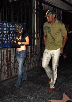 Dennis Rodman leaves Mood Nightclub with a female friend. 9311,HOLLYWOOD, CALIFORNIA- Wednesday 22 March 2006. Dennis Rodman and a female friend leave Mood Nightclub wearing camouflage hats. Photograph: Adrian Varnedoe, Pacificcoastnews.com. UK: +44 131 225 3333 3322 USA: +1 310 261 9676, Credit:Adrian Varnedoe Avalon USA  Copyright: xAdrianxVarnedoex xAvalonx 0520137204