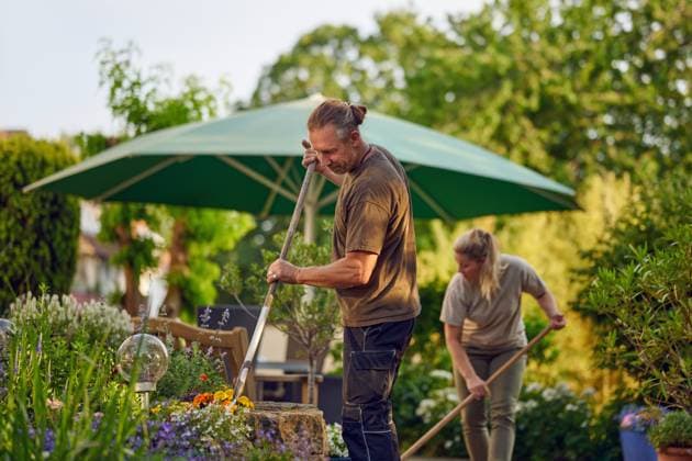 Handwerker fegen die Terasse Male gardener raking the the flower bed while the collegue is sweeping the terrace in summer ,model released, Symbolfoto ,property released Copyright: xZoonar.com LarsxZahnerx 20690675 ,model released, Symbolfoto ,property released