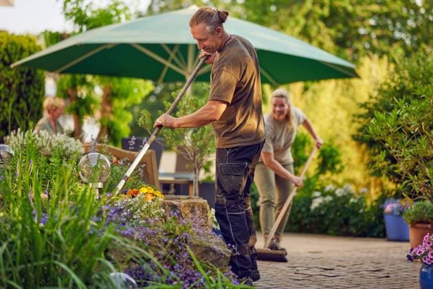 Handwerker fegen die Terasse Male gardener raking the the flower bed while the collegue is sweeping the terrace in summer ,model released, Symbolfoto ,property released Copyright: xZoonar.com LarsxZahnerx 20690717 ,model released, Symbolfoto ,property released
