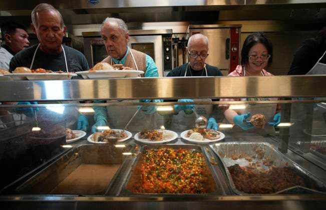 (231210) -- VANCOUVER, Dec. 10, 2023 -- Volunteers dispense food inside a kitchen during the annual Christmas dinner at Union Gospel Mission (UGM) in Vancouver, British Columbia, Canada, on Dec. 9, 2023. (Photo by Xinhua) CANADA-VANCOUVER-CHRISTMAS-CHARITY DINNER LiangxSen 
