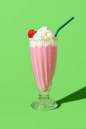Strawberry milkshake with whipped cream, minimalist on a green background Strawberry flavored milkshake in bright light, minimalist on a green colored table. Delicious homemade milkshake with vanilla ice cream, strawberries and topped with whipped cream. Copyright: xZoonar.com DanielaxSimonaxTemneanux 20710370