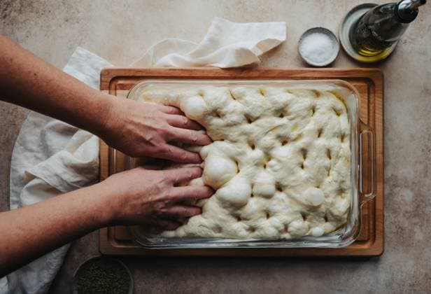 Creative Highlights Symbolbilder Hands making holes in risen focaccia dough shot from above. Kingston, Ontario, Canada CR_DOHO231207H-1299945-01 ,model released, Symbolfoto