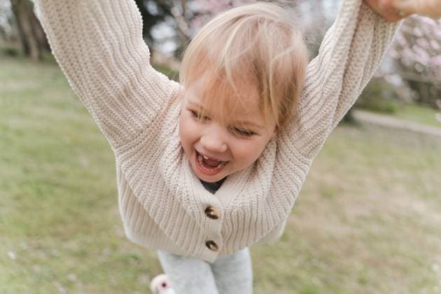 Creative Highlights Symbolbilder Cute blonde girl having fun in the park near a blooming magnolia Trezzo sull Adda, Lombardy, Italy R_NEPM231207-1243940-01 ,model released, Symbolfoto