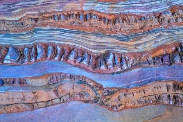 A close-up of vibrant, multi-colored sedimentary rock layers exhibiting natural stratification and weathering. Model Released CesarLlaneza_ID17883_539129_009 Copyright: xCesarxLlanezax