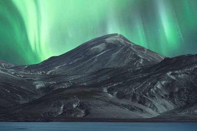 A mesmerizing display of the Northern Lights, or aurora borealis, illuminating the night sky above a majestic snow-covered mountain in the Icelandic wilderness. Model Released JuanLopez_ID17877_538974_006 Copyright: xJuanxLopezx