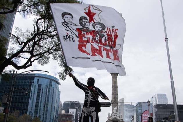Demonstration of Teachers For The 44th Anniversary of the Labor Union December 15, 2023 Mexico City, Mexico. A hooded person waves a flag, during a demonstration of the the National Coordinator of Education Workers in Mexico at Reforma Avenue to demand improvements to the education system and better salaries within the framework of the 44th anniversary of their union group. on December 15, 2023 in Mexico City, Mexico. (Photo by Alex Dalton Eyepix Group) Copyright: xAlexxDalton xEyepixxGroupx AD_15122023_107372