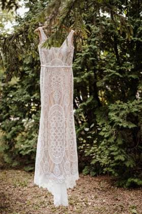 full length lace wedding dress hanging from a tree branch Winnipeg, Manitoba, Canada R_MFBW231215-1306790-01