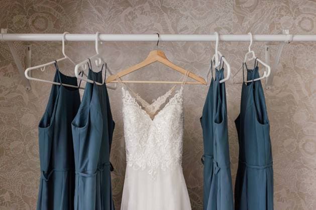 Wedding Dress hanging in closet with blue bridesmaids dresses Winnipeg, Manitoba, Canada R_MFBW231214D4-1304652-01