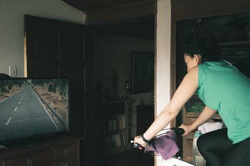 Indoor shot of a female doing fitness training on a spinning bicycle at home. 330506 ,model released, Symbolfoto ,property released RECORD DATE NOT STATED