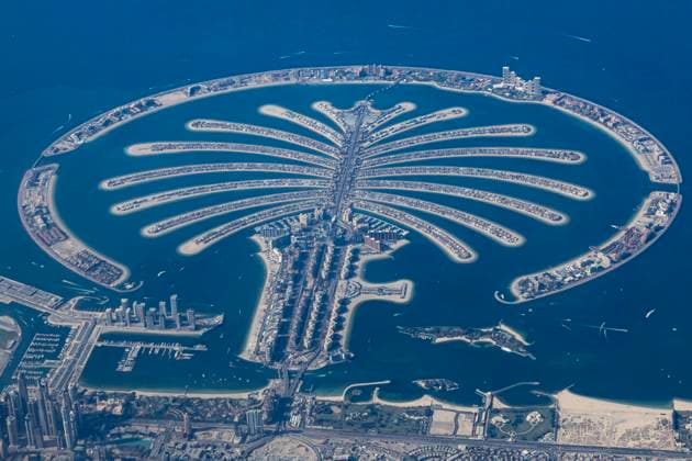 Aerial View Of Palm Jumeirah Aerial view from an airplane window of Palm Jumeirah artificial islands over the city view, on the Persian Gulf in Jumeirah, Dubai, United Arab Emirates part of the Palm Islands developments, increasing Dubai s shoreline. The islands in the archipelago were created using land reclamation. The Palm Jumeirah construction was done by a Dutch specialist dredging company, Van Oord. The islands have residential housing units, hotels, resorts, retail and dining shops, restaurants and markets in addition to the venues and recreational areas near the sandy beach. Apart from road and boat the island has a monorail transportation system. It is one of the most recognizable symbols, landmark of Dubai. Dubai, UAE on December  Copyright: xNicolasxEconomoux originalFilename: economou-aerialvi231210_np4l1.jpg
