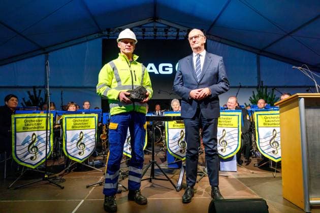 Schichtwechsel im Tagebau Jaenschwalde DEU Deutschland Brandenburg Jaenschwalde, 22.12.2023, Ende der Kohlefoerderung im Tagebau Jaenschwalde, Steiger Michael Kadler (LEAG) uebergibt symbolisch das letzte Stueck Braunkohle aus dem Tagebau Jaenschwalde an den brandenburgischen Ministerpraesidenten Dietmar Woidke (SPD). Mit einem feierlichen Schichtwechsel endet nach 47 Jahren am 22.12.2023 die Kohlefoerderung im Braunkohletagebau Jaenschwalde des lausitzer Energieunternehmens LEAG. *** Shift change at Jaenschwalde opencast mine DEU Germany Brandenburg Jaenschwalde, 22 12 2023, End of coal production at Jaenschwalde opencast mine, Steiger Michael Kadler LEAG symbolically hands over the last piece of lignite from the Jaenschwalde opencast mine AF_LEAG_Schichtwechsel_88169.jpeg