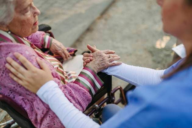 Healthcare worker holding hands and consoling senior woman model released, Symbolfoto, HAPF03389
