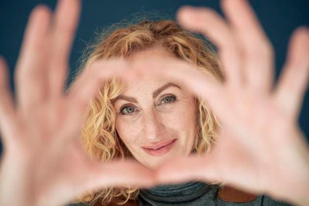 Creative Highlights Symbolbilder Smiling woman gesturing heart shape model released, Symbolfoto property released, JOSEF22082