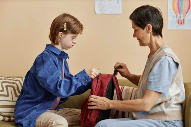 Woman and girl with disability packing backpack while preparing for school model released, Symbolfoto property released, KPEF00420