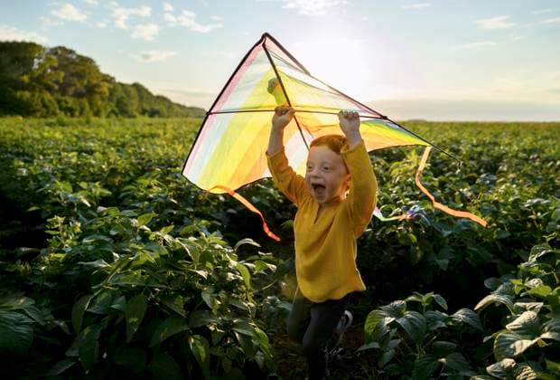 Creative Highlights Symbolbilder Playful boy holding kite and running in agricultural field model released, Symbolfoto, MBLF00158