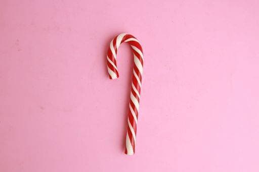 A top view of a candy cane under the lights against a pink background 723786 RECORD DATE NOT STATED