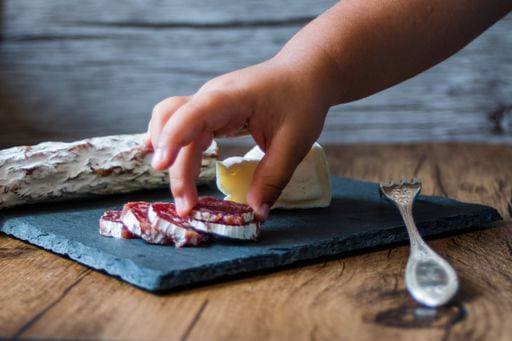A closeup shot of brie cheese and smoked sausages on a board 736439 RECORD DATE NOT STATED