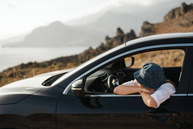 Young woman leaning on car window looking at coastal landscape Foinikas, Greece R_AKAO240102E3-1313979-01 ,model released, Symbolfoto