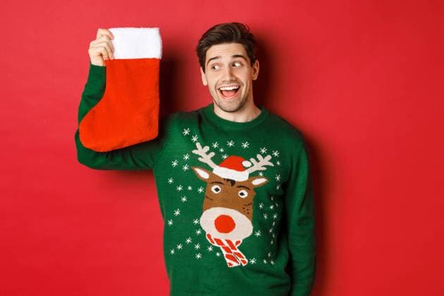 Image of surprised and amused man in green sweater, looking at christmas stocking with presents and smiling, standing over red background Image of surprised and amused man in green sweater, looking at christmas stocking with presents and smiling, standing over red background. ,model released, Symbolfoto Copyright: xZoonar.com SevaxLevitskyx 17497332 ,model released, Symbolfoto ,property released