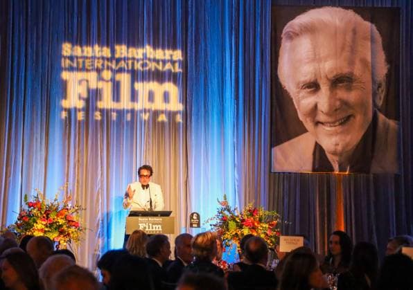 January 13, 2024, Santa Barbara, California, U.S.A: Executive Director of SBIFF Roger Durling welcomes guests and talks about the man of honor Ryan Gosling while Kirk Douglas smiles down from a giant photo against a blue curtain during the Kirk Douglas Award for Excellence in Film fundraising gala for the Santa Barbara International Film Festival 2024, on January 13. The exclusive dinner event was held at the Ritz-Carlton Hotel, Santa Barbara. Santa Barbara U.S.A - ZUMAk144 20240113_znp_k144_066 Copyright: xAmyxKatzx