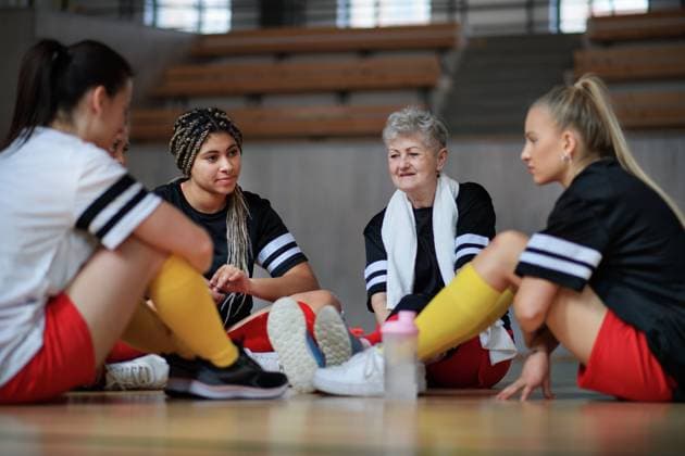 Group of young and old women, sports team players in gym sitting and talking after training. Group of young and old women, sports team players in gym sitting and talking after match. model released Copyright: xx Big_ESkola_Woman_Team_Sport_2022_147