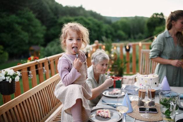 IMAGO Creative: Sommer, Sommertage im Garten Little girl enjoying eating birthday cake during multi generation family celebration outside on patio. A little girl enjoying eating birthday cake during multi generation family celebration outside on patio. model released Copyright: xx HHH FAMILY GRILL BODOVCI 2022 HHH 573
