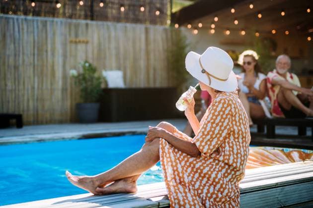 Senior woman enjoying time at swimmingpool with her family. Senior woman enjoying summer time at swimmingpool with her family. model released Copyright: xx HHH FAMILY POOL PARTY 2022 HHH 345
