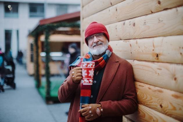 Happy senior man enjoying christmas market, drinking muled wine. Happy senior man enjoying outdoor christmas market, drinking punch. model released Copyright: xx HHH SENIORS CHRTISTMAS MARKET 2022 HHH 094-2