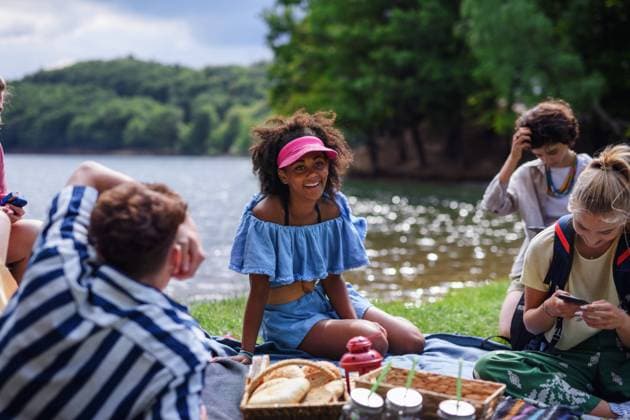 Group of multiracial young friends camping near lake and and having barbecue together. A group of multiracial young friends camping near lake and and having barbecue together. model released Copyright: xx HHH SUMMER FRIENDS BS 2022 HHH 141
