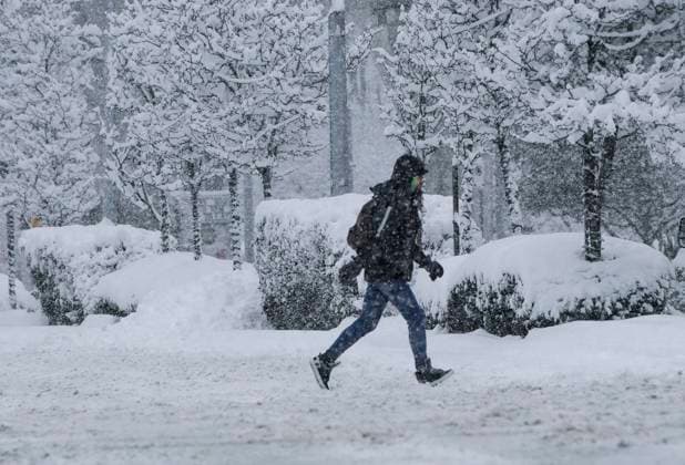 (240117) -- VANCOUVER, Jan. 17, 2024 -- A person crosses a street in the snow in Vancouver, British Columbia, Canada, on Jan. 17, 2024. Environment Canada issued a snowfall warning for the province of British Columbia on Wednesday. The Metro Vancouver region saw up to 20 centimetres of snow, causing schools to close and flights to be delayed and cancelled. (Photo by Xinhua) CANADA-VANCOUVER-HEAVY SNOW LiangxSen 