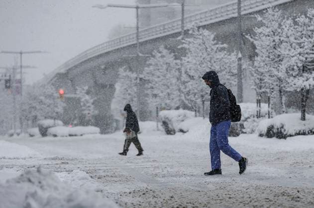 (240117) -- VANCOUVER, Jan. 17, 2024 -- People cross a street in the snow in Vancouver, British Columbia, Canada, on Jan. 17, 2024. Environment Canada issued a snowfall warning for the province of British Columbia on Wednesday. The Metro Vancouver region saw up to 20 centimetres of snow, causing schools to close and flights to be delayed and cancelled. (Photo by Xinhua) CANADA-VANCOUVER-HEAVY SNOW LiangxSen 